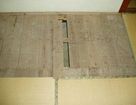 1階床下の調査は和室の畳の一部を上げて実施したが、畳を上げたところ、釘が抜かれ、0から7までの番号が付された床板があり、業者が出入口として使用していたと思われる。
